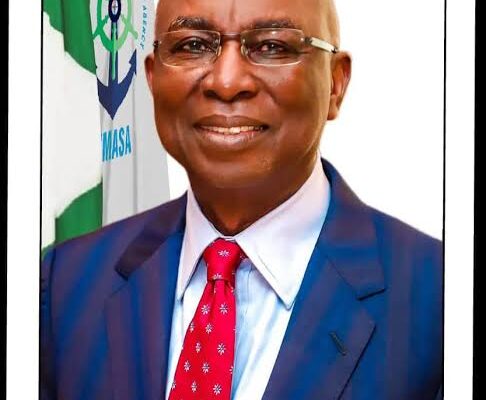 Formal portrait with Nigerian flag background.